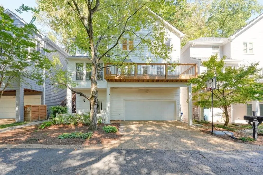 Multi-level exterior featuring horizontal siding, a raised wood deck with railing, and an attached two-car garage
