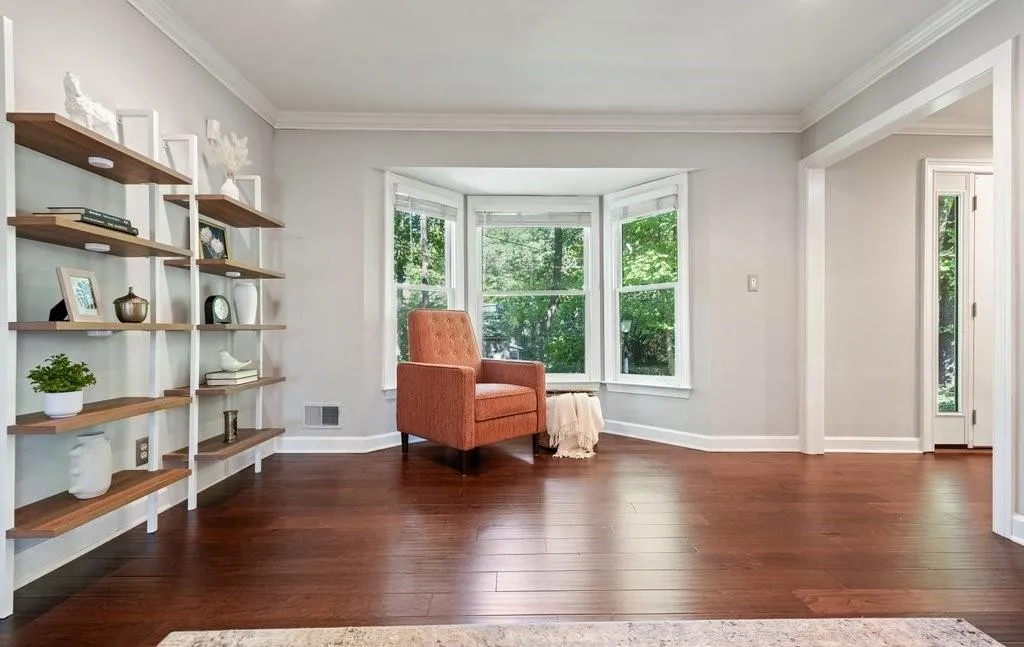 Bay window featuring crisp white casing, extensive wood-finish flooring, and built-in wall shelving