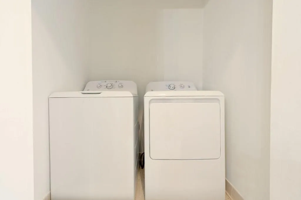 Recessed laundry alcove featuring white walls and dedicated utility space for side-by-side appliances