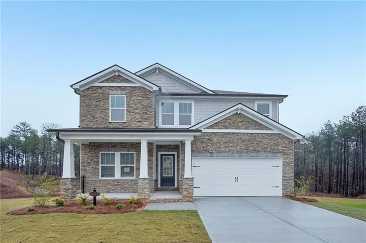 Craftsman inspired home featuring stone siding, covered porch, concrete driveway, and a front lawn