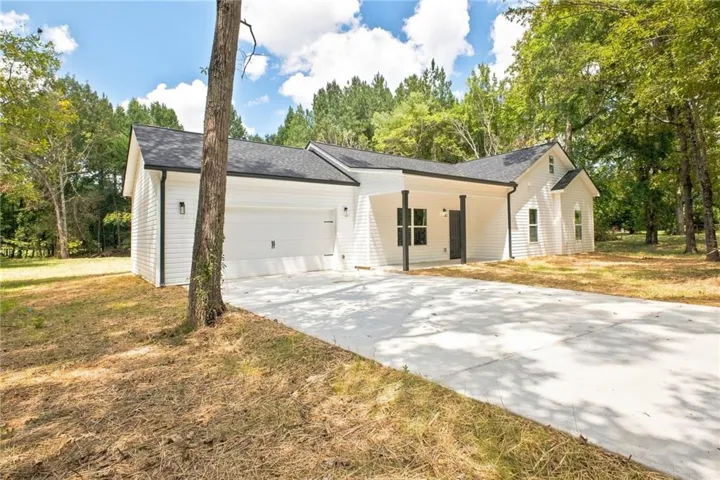 White siding exterior with a dark shingle roof and a covered entry
