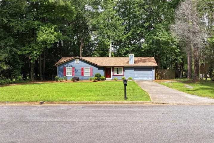 Ranch-style exterior with blue siding, red shutters, and a front porch