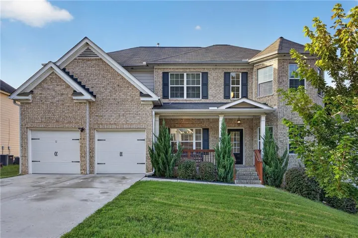 Traditional-style residence featuring a brick facade and a two-car garage