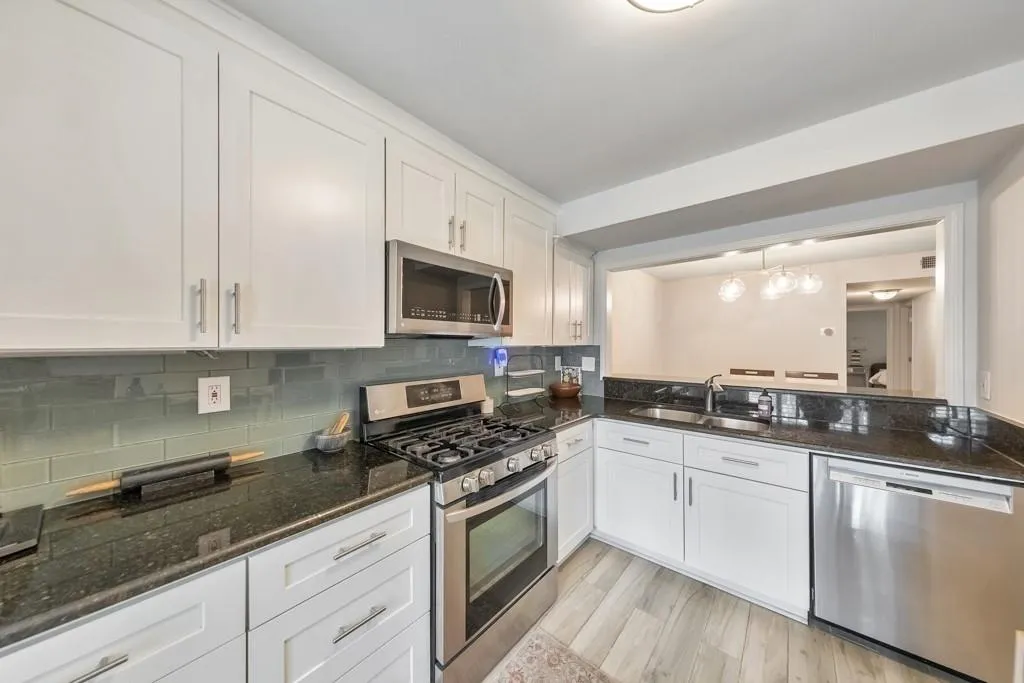 BEAUTIFUL TILED BACKSPLASH IN KITCHEN COMPLIMENTS THE WHITE CABINETS AND GRANITE COUNTERTOPS!!