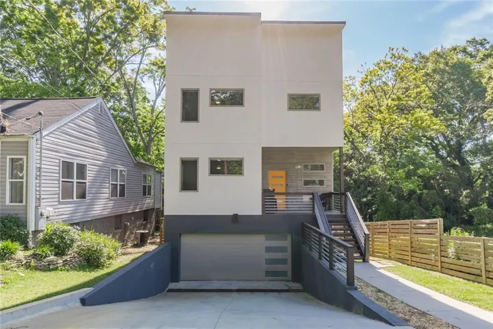 Contemporary multi-story residence featuring a flat roofline and a two-tone exterior