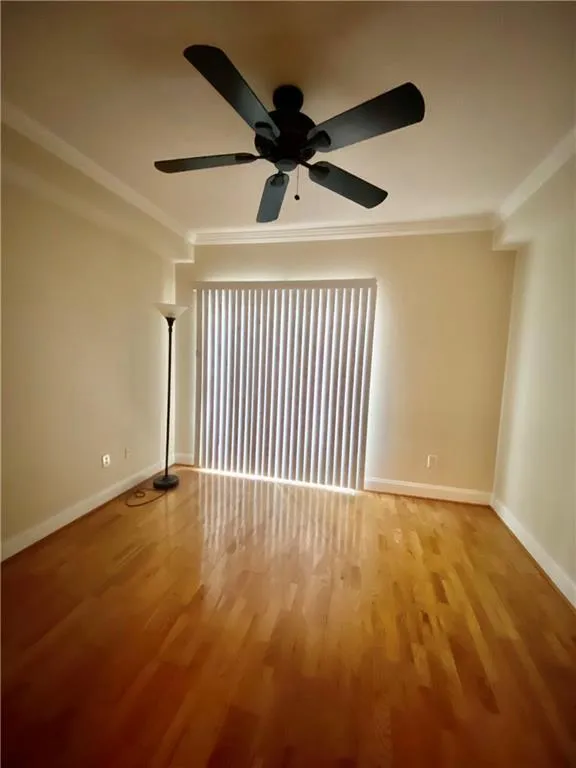 Unfurnished room featuring ornamental molding, wood finished floors, and ceiling fan