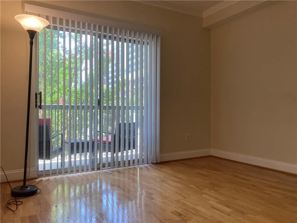 Empty room featuring ornamental molding and wood finished floors
