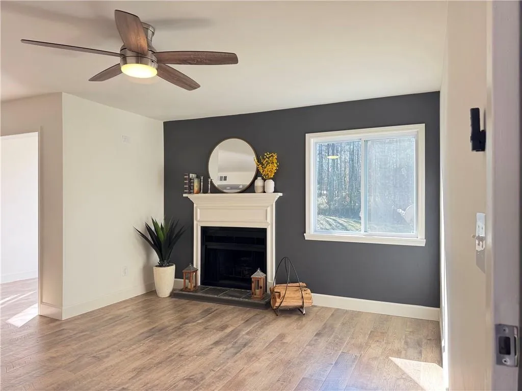 Living room with luxury vinyl floring, fireplace and ceiling fan
