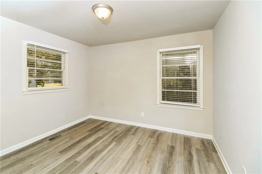 Unfurnished room with light wood-type flooring and baseboards