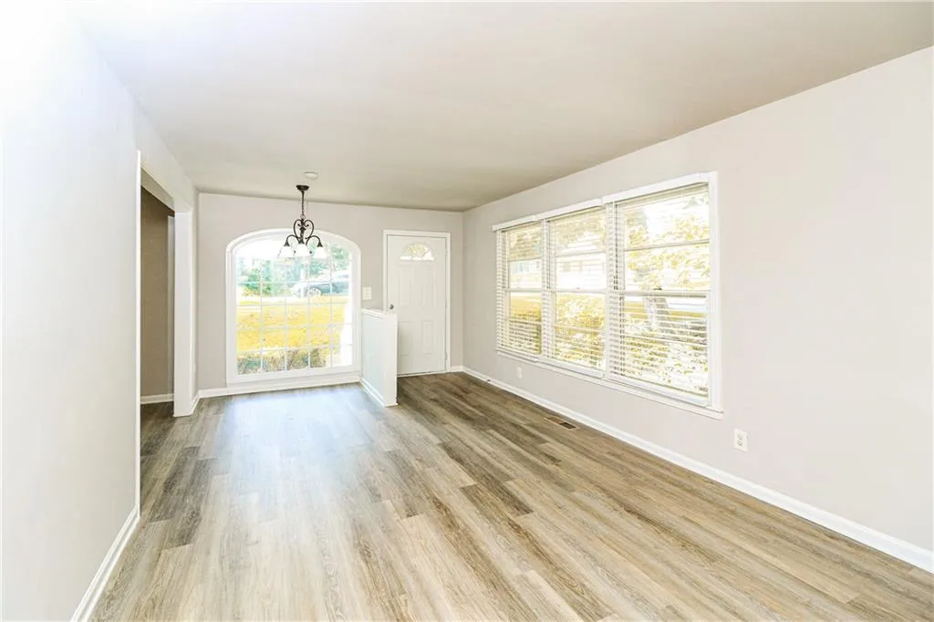 Empty room featuring a chandelier and light wood finished floors