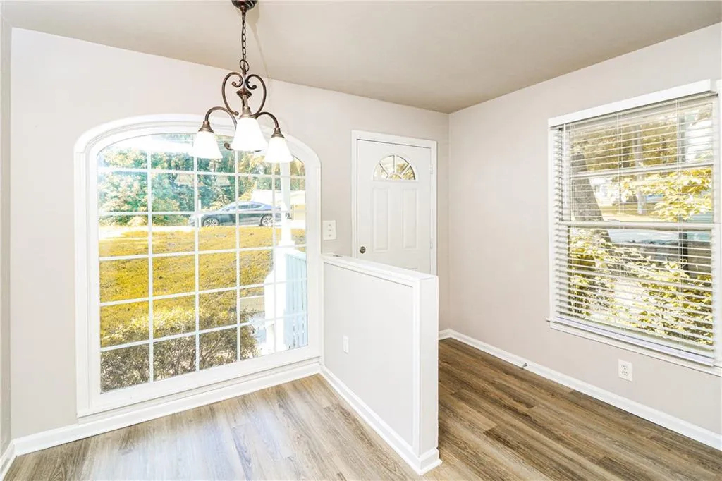 Entrance foyer featuring wood finished floors, plenty of natural light, and a chandelier