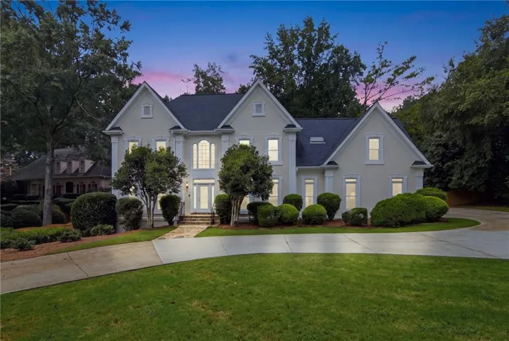Stately two-story stucco exterior with a dark shingle roof and multiple gables