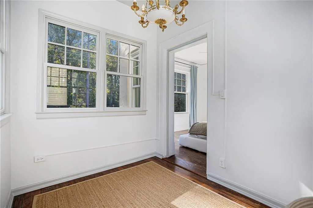 Unfurnished room featuring dark wood-type flooring and a chandelier