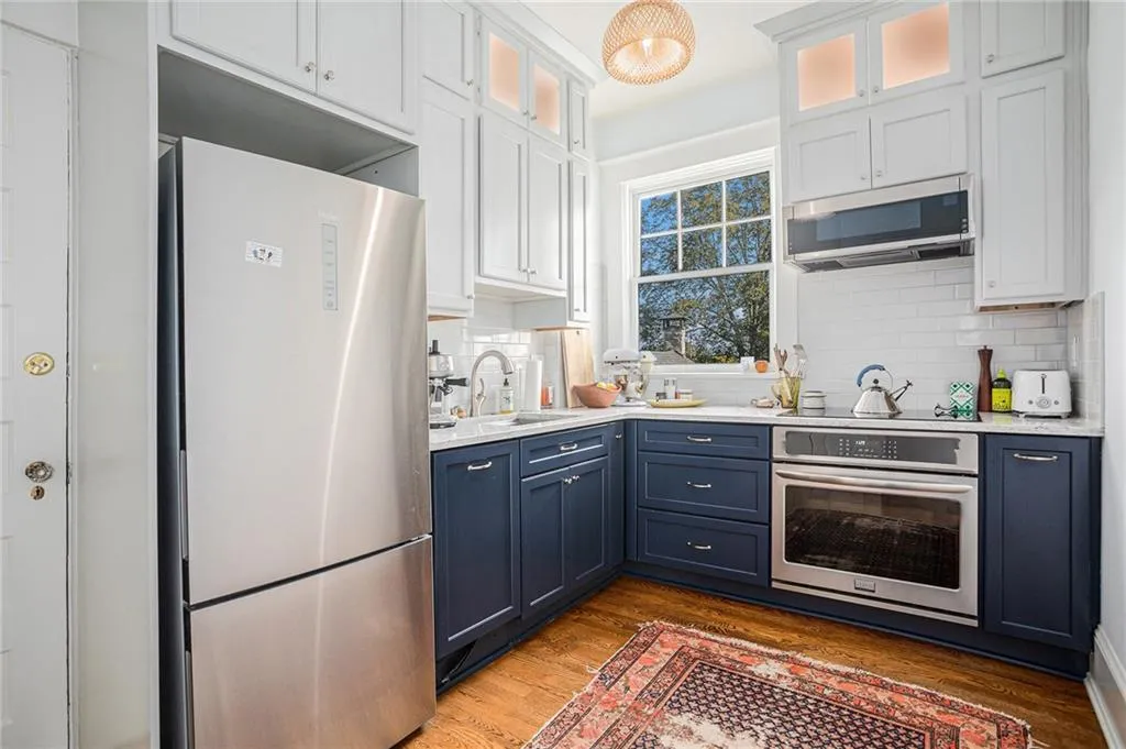 Kitchen featuring blue cabinets, appliances with stainless steel finishes, sink, and white cabinets