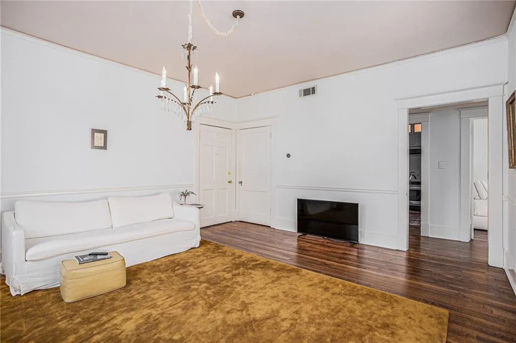 Unfurnished living room with an inviting chandelier, a fireplace, and dark hardwood / wood-style floors