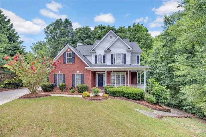 Traditional brick and siding exterior with dark shutters