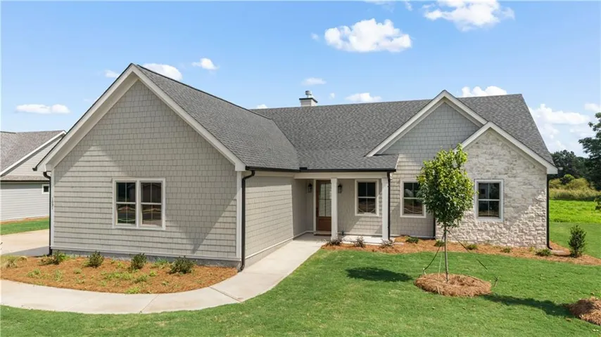 Craftsman-style exterior featuring a combination of shingle siding and stone veneer
