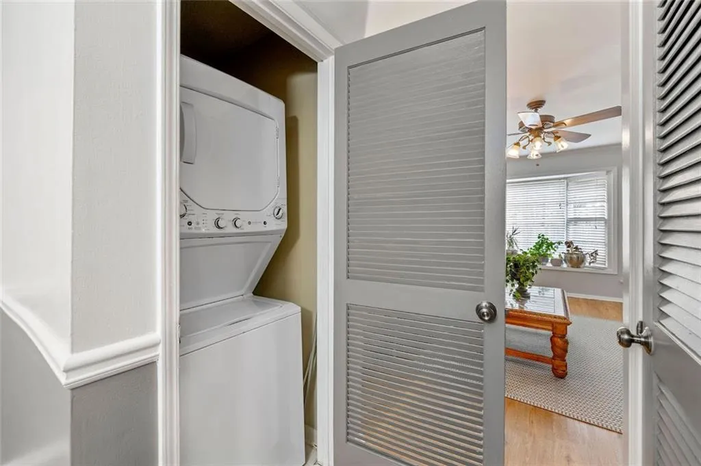 Washroom with light wood-type flooring, ceiling fan, and stacked washer and dryer Washroom with light wood-type flooring, ceiling fan, and stacked washer and dryer