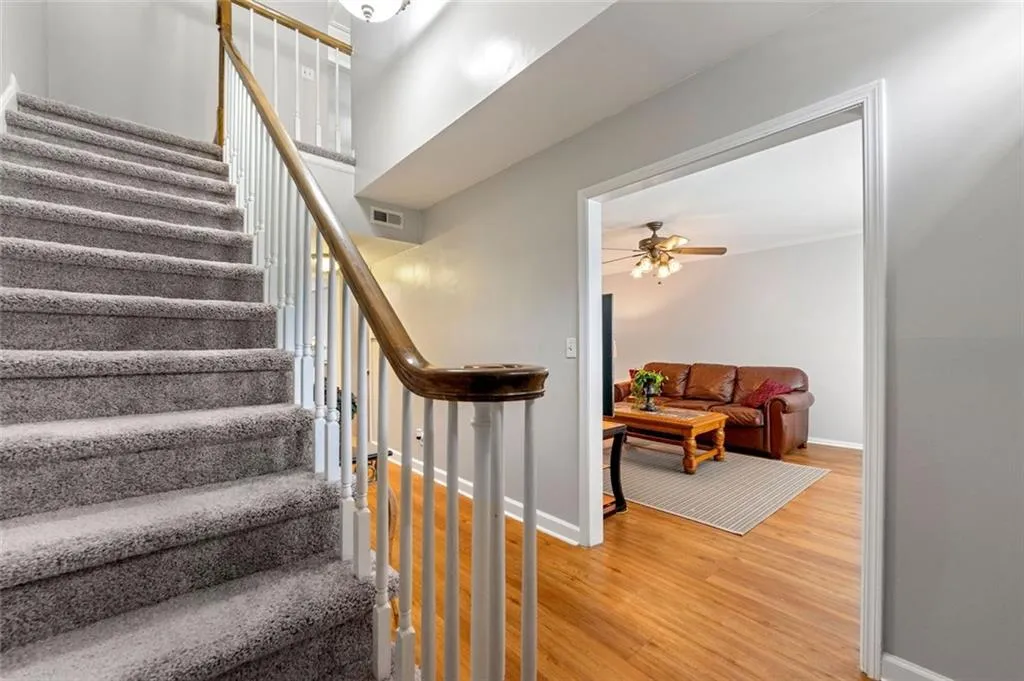 Staircase featuring ceiling fan and hardwood / wood-style floors Staircase featuring ceiling fan and hardwood / wood-style floors