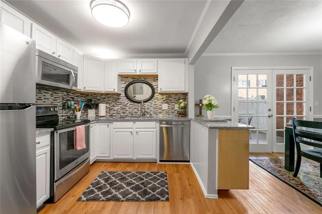 Kitchen with stainless steel appliances, light hardwood / wood-style flooring, and tasteful backsplash Kitchen with stainless steel appliances, light hardwood / wood-style flooring, and tasteful backsplash