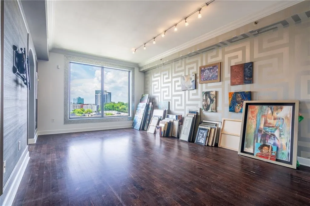 Living room featuring hardwood / wood-style flooring, ornamental molding, rail lighting, and wallpapered walls