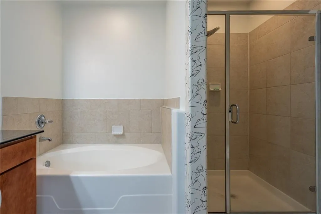Bathroom featuring a bath and a shower stall