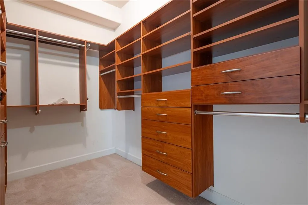 Primary Walk in closet featuring light carpet