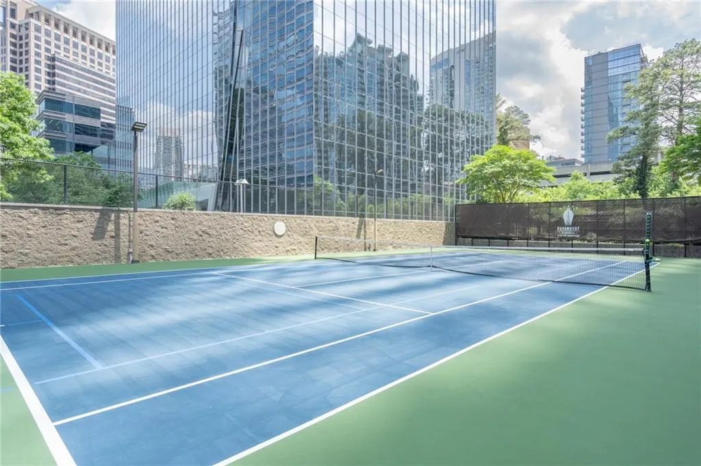 View of tennis court with community basketball court and a view of city