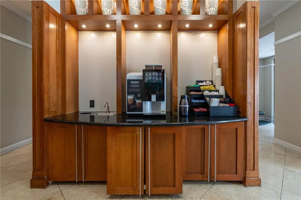 Indoor wet bar featuring crown molding and light tile patterned floors