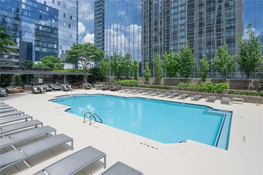 Community pool with a patio and outdoor lounge area