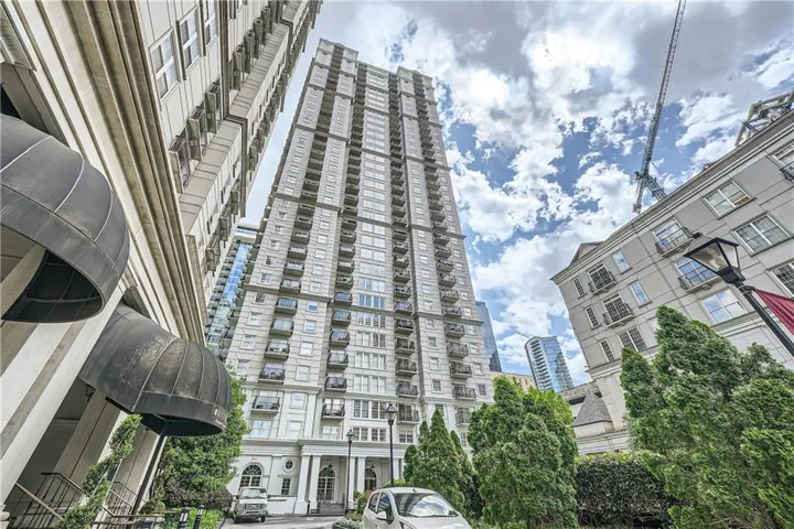 Contemporary high-rise building featuring a stone facade and individual balconies