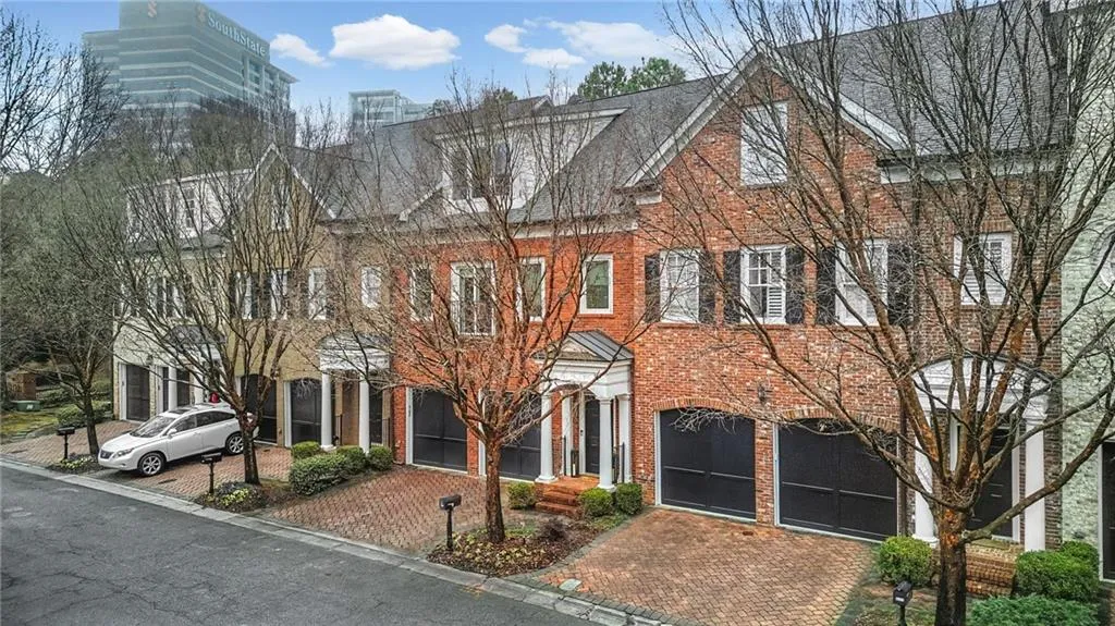 View of front of home featuring driveway, an attached garage, and brick siding