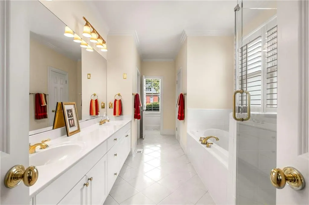 Primary bathroom is amply sized and has double sinks, air bubble soaking tub, frameless glass shower, and a separate water closet