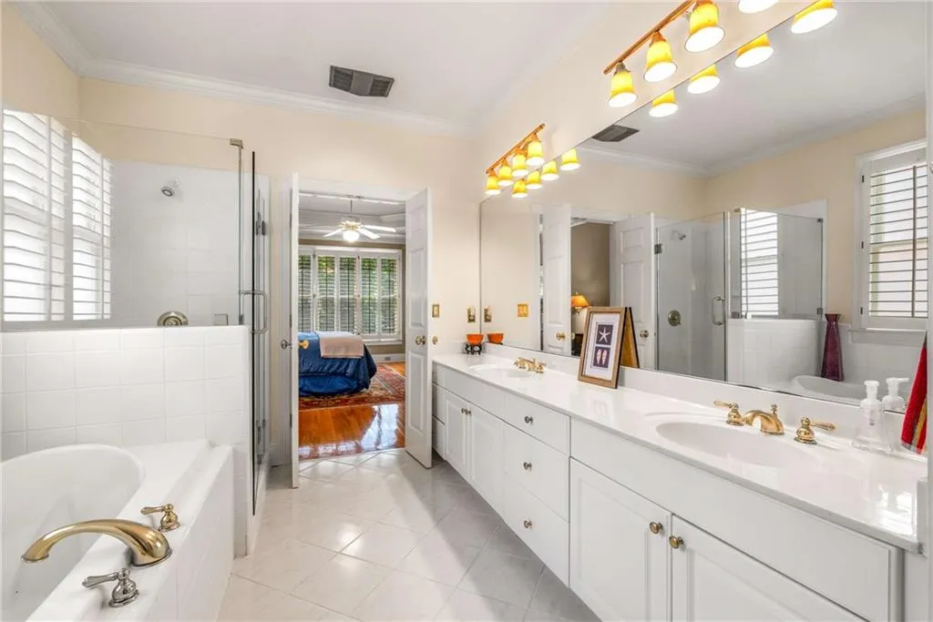 Primary bathroom is amply sized and has double sinks, air bubble soaking tub, frameless glass shower, and a separate water closet