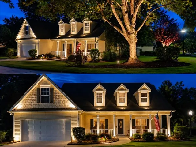 Exterior showcasing dormer windows, a covered front porch with white columns, attached two-car garage, and extensive landscape lighting