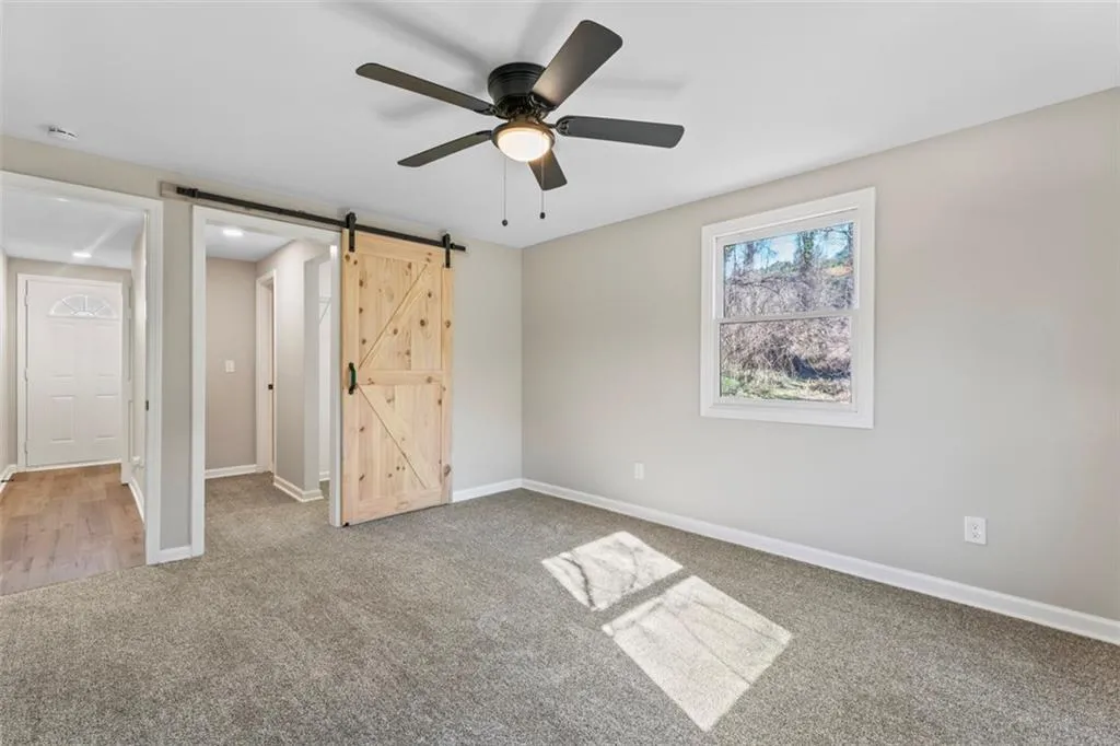 Owners suite with barn door opening to private closet and bath.  Virtually staged.