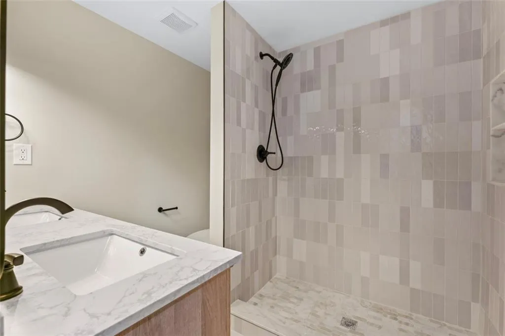 Owners suite private Bathroom featuring double vanity and a sink