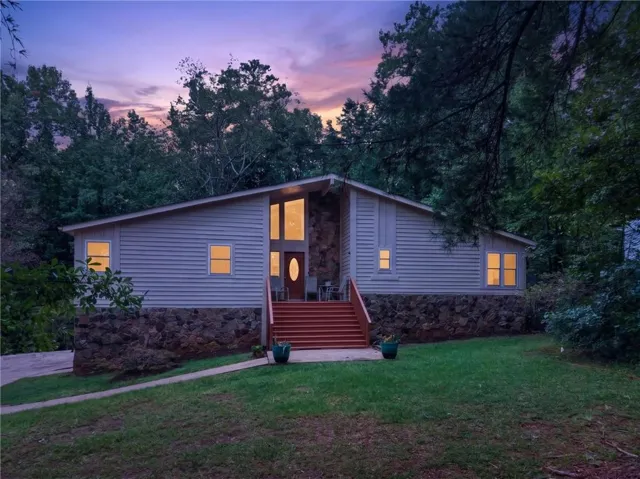 Siding exterior with stone foundation and red-toned entry stairs