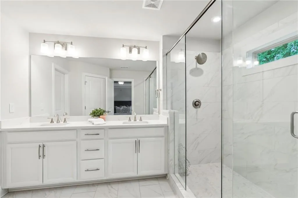 Bathroom with a marble finish shower, marble finish flooring, double vanity, and ensuite bathroom