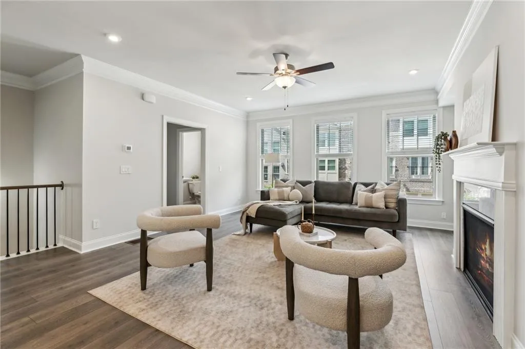 Living room featuring ornamental molding, ceiling fan, dark wood-style flooring, a high end fireplace, and recessed lighting