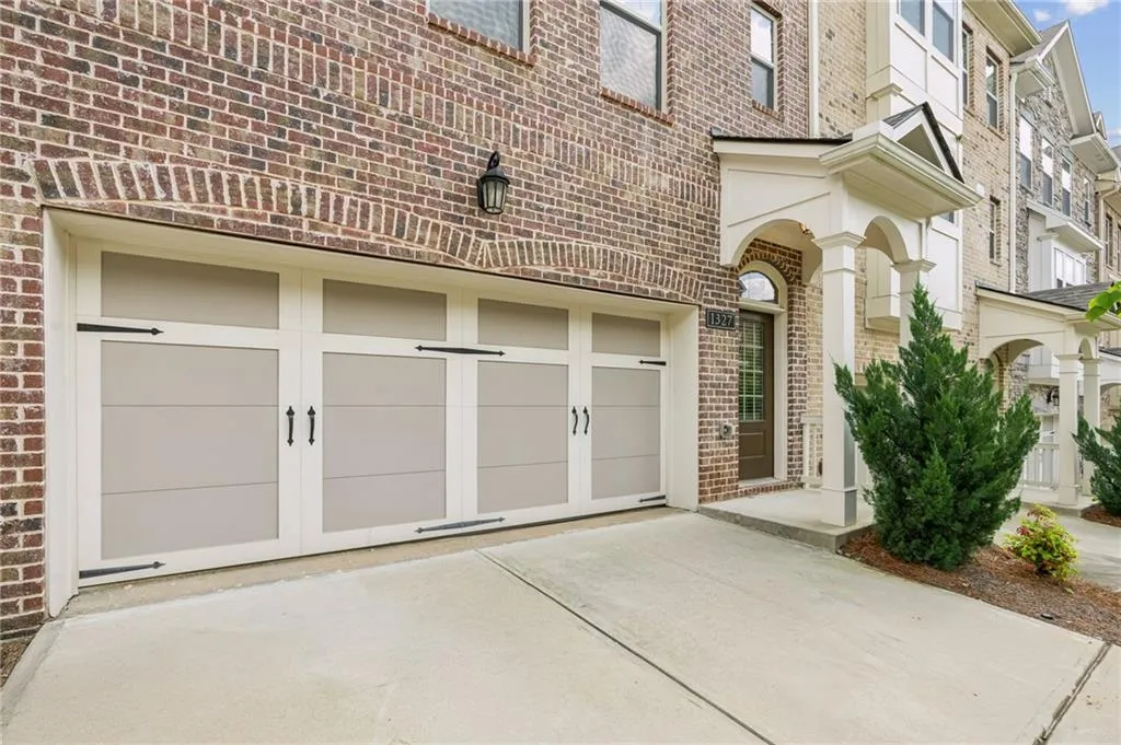 Doorway to property with brick siding, concrete driveway, and an attached garage