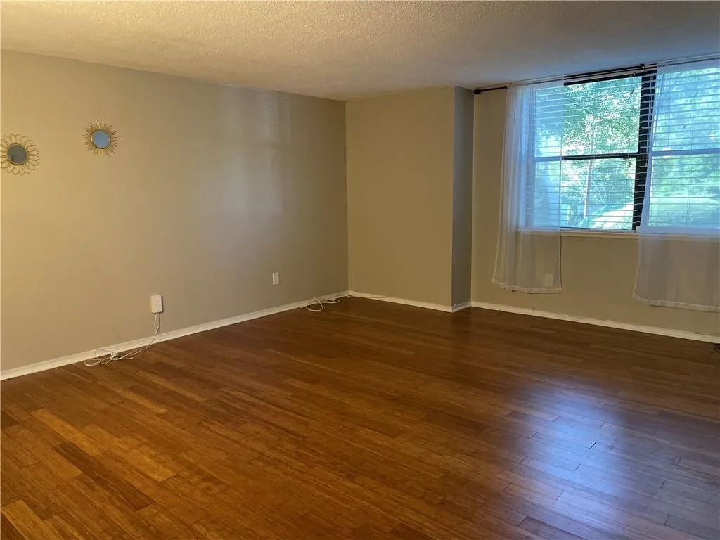 Spare room featuring a textured ceiling and dark wood finished floors