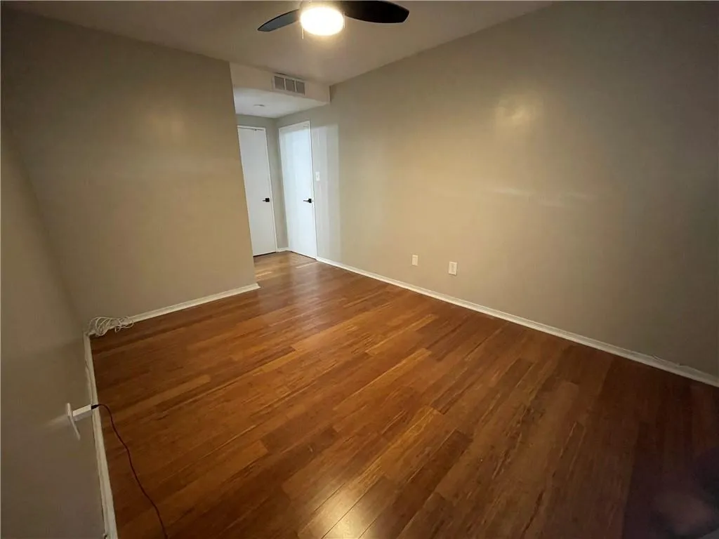 Spare room with wood finished floors and ceiling fan