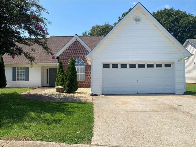 Brick and siding exterior with an attached garage featuring window inserts