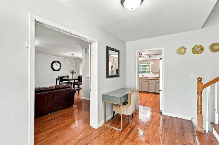 Hardwood-finish flooring throughout, light gray wall paint, and a wood staircase with balusters