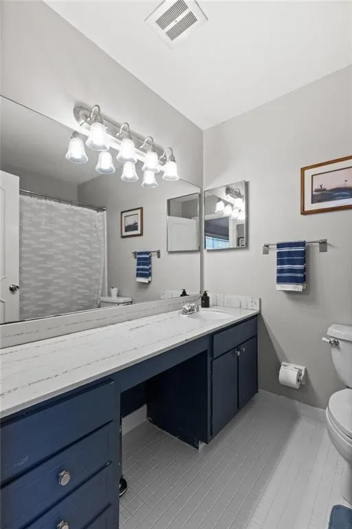Bathroom featuring vanity, toilet, and tile flooring