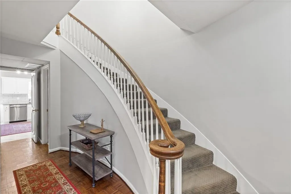 Stairs featuring dark parquet flooring