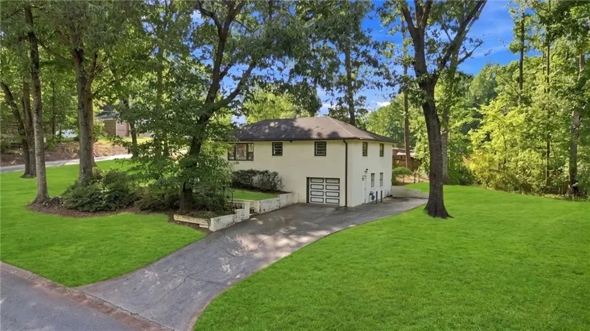 Two-story residence with a white exterior, attached garage, and a long paved driveway