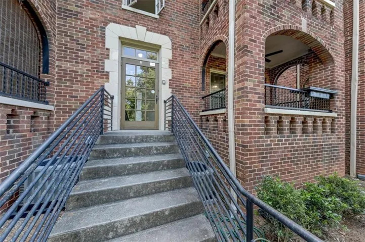 Brick exterior with stone accents, architectural archways, and a glass-paneled entry door