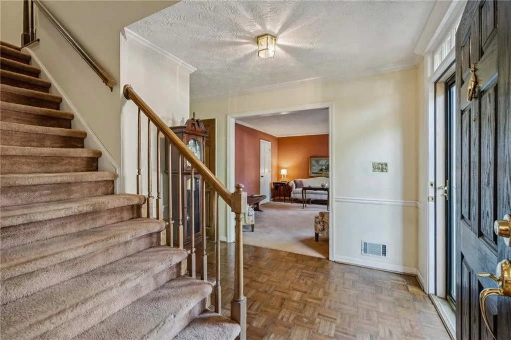 Bright Foyer entrance with crown molding and parquet floors.